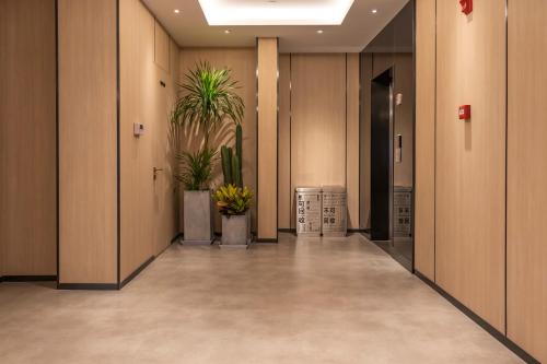 an empty hallway with potted plants in a building at WeLight Hotel in Beijing