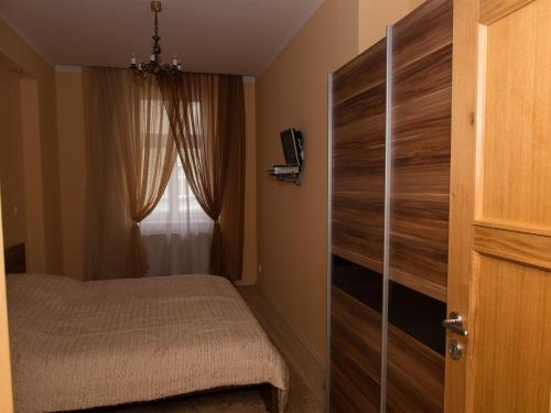 a bedroom with a bed and a door with a window at Apartman "Alika" in Karlovy Vary