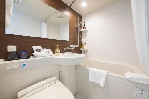 a bathroom with a sink and a toilet and a tub at Quintessa Hotel Fukuoka Tenjin Minami in Fukuoka