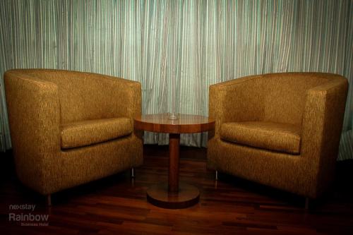 two chairs and a table in a room at New Rainbow Business Hotel in Bengaluru