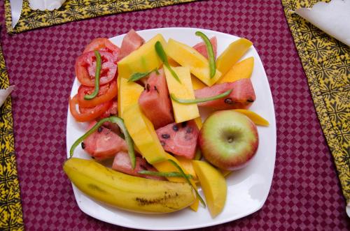 a plate of fruit and vegetables on a table at Agenda 2000 Hotels Ltd in Kampala