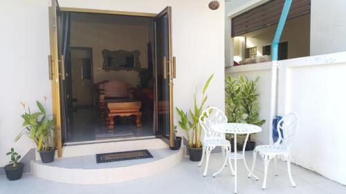 a patio with a table and chairs and a table at Old City 2 bedroom House in Chiang Mai
