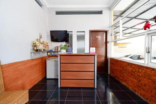 a kitchen with a counter with a sink and a tv at SUPER OYO 2209 Solo Point Guest House Syariah in Solo