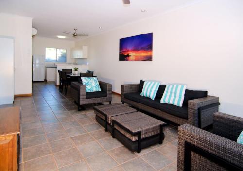 a living room filled with furniture and a couch at Cable Beach Apartments in Broome