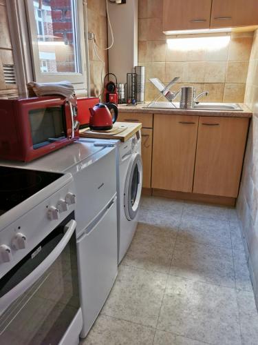 une cuisine avec une cuisinière et une machine à laver dans l'établissement Studio bien placé pour visiter Paris, à Vincennes