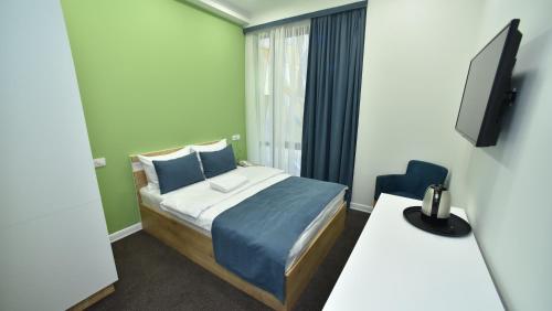 a small room with a bed and a television at Bonjour Boutique Hotel Yerevan in Yerevan