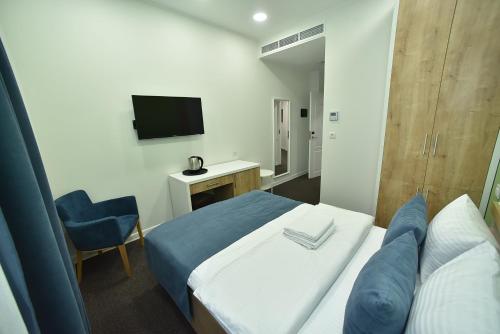 a hotel room with a bed and a television at Bonjour Boutique Hotel Yerevan in Yerevan