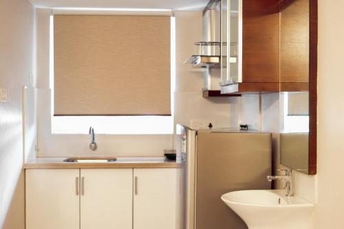 a small kitchen with a sink and a refrigerator at D Homz Suites in Cochin