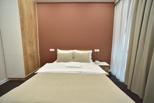 a bedroom with a large bed with white sheets at Bonjour Boutique Hotel Yerevan in Yerevan