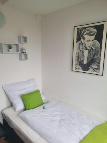 Bett in einem Zimmer mit einem Bild an der Wand in der Unterkunft Studiotel TOP LOFT in Düsseldorf