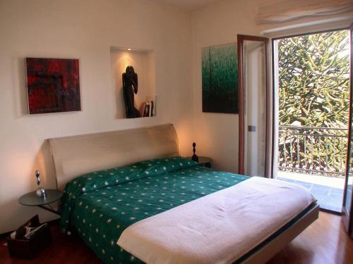 1 dormitorio con cama y ventana grande en Villa Niccolò, en Cadenabbia