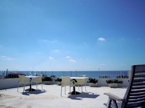 a patio with a table and chairs and the ocean at Vistamare in Alliste
