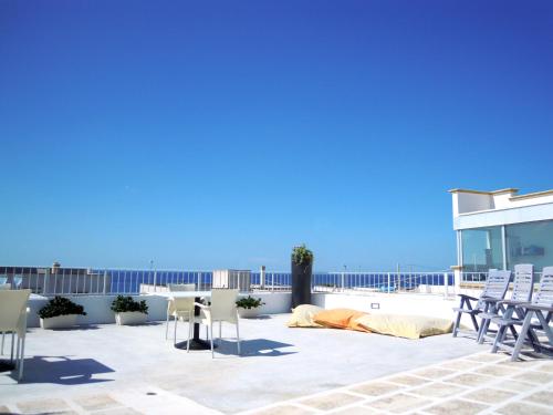 a patio with chairs and a table on a roof at Vistamare in Alliste