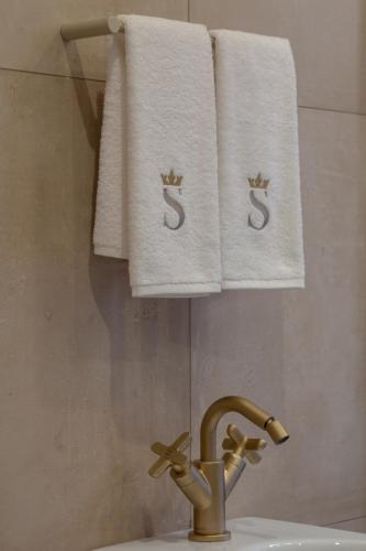 a bathroom with white towels and a sink with a faucet at Dimora Storica Lo Svevo in Iesi