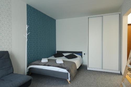 a bedroom with a bed and a chair at Delightful Apartment - FREE PARKING - NETFLIX in Kaunas