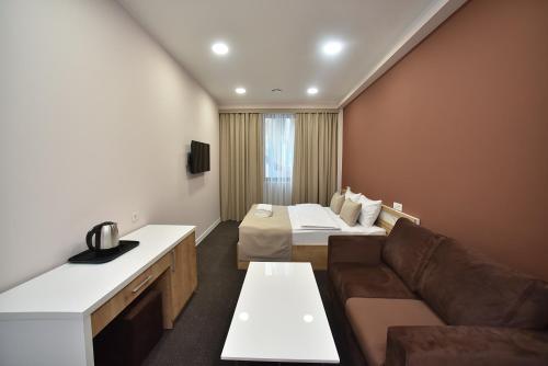 a living room with a couch and a bed in a room at Bonjour Boutique Hotel Yerevan in Yerevan