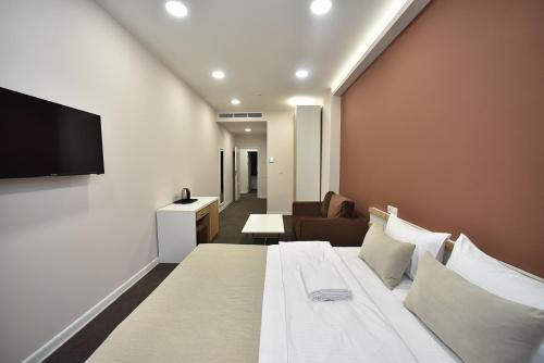 a hotel room with a bed and a flat screen tv at Bonjour Boutique Hotel Yerevan in Yerevan