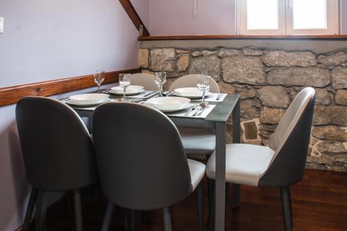 a dining room table with chairs and a stone wall at Villa Domina in Split