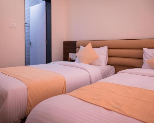 two beds sitting next to each other in a room at Hotel Sharda Residency in Mangalore