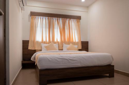 a bedroom with a large bed with a window at Hotel Sharda Residency in Mangalore