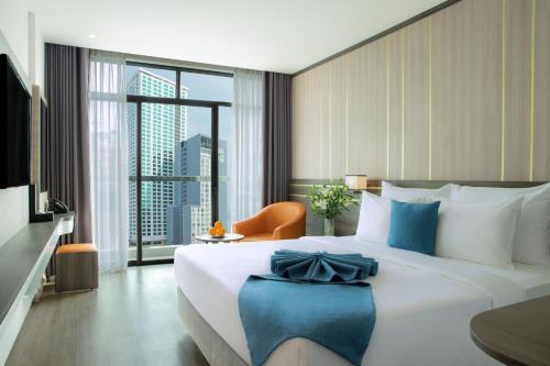 a hotel room with a large bed and a large window at Seana Hotel in Nha Trang