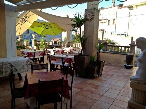 um restaurante com mesas e cadeiras e um guarda-sol amarelo em B&B Vico Vacanze em Vico del Gargano