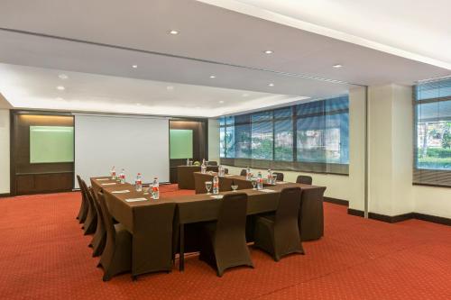 a conference room with a long table and chairs at Hotel Santika Bandung in Bandung