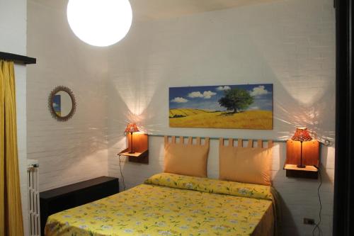 a bedroom with a bed and two lights on the wall at Appartamento La Perla a soli 100m dal mare a Marina di Castagneto in Marina di Castagneto Carducci
