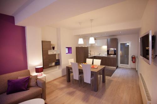 a living room and kitchen with a table and chairs at Feels Like Home Apartments in Zagreb