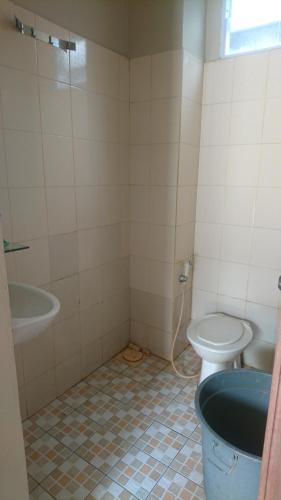 a bathroom with a toilet and a sink and a tub at Liberty Homestay in Parit