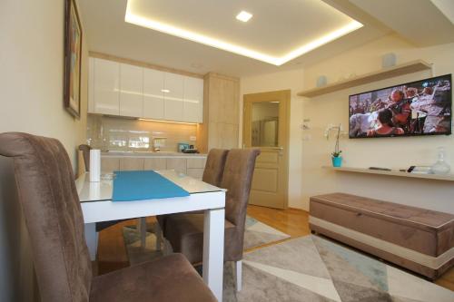 a kitchen and dining room with a table and chairs at Apartman Vip Aleksa Zlatibor Centar in Zlatibor