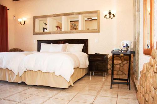 a bedroom with a large bed and a mirror at Stephan's Guest House in Port Shepstone