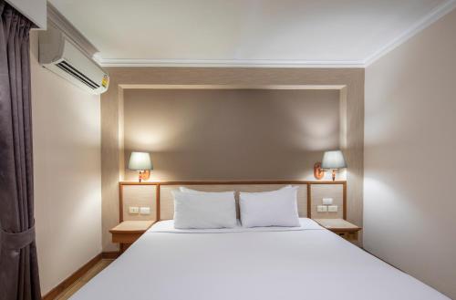 a bedroom with a white bed with two night stands at Station ONE Hotel - Aranyaprateth in Aranyaprathet