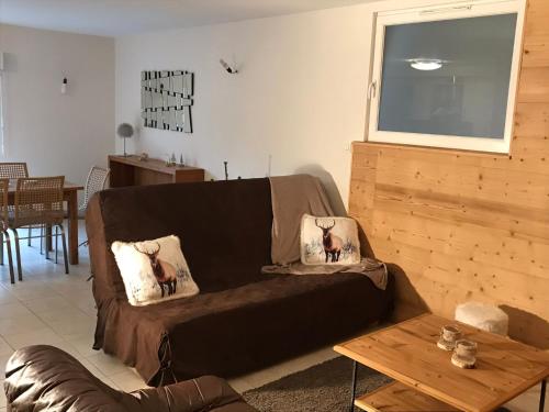 a brown couch in a living room with a table at Appartement 6 pers - Les 4 Loups au pied des pistes in Gérardmer