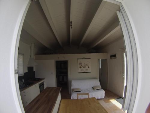 uma porta arqueada para uma cozinha com uma cama num quarto em le pied marin em Ker Pierre Borny