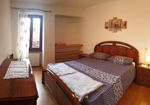 una camera con letto, tavolo e finestra di La Rotonda apartments by Gardadomusmea a Tremosine Sul Garda