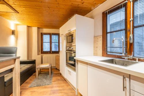 a kitchen with white cabinets and a sink at Le Duplex du Lac in Évian-les-Bains