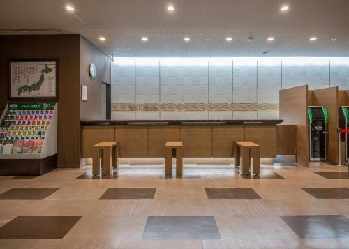 a restaurant with two benches and a counter with at Hotel Route Inn Grand Asahikawa Ekimae in Asahikawa
