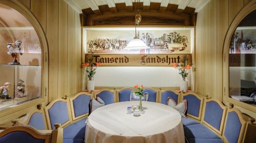 a dining room with a table and blue chairs at Restaurant-Café-Pension Himmel in Landshut