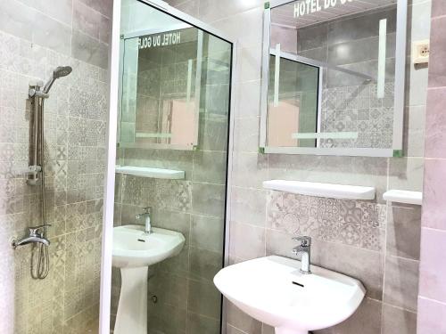 a bathroom with two sinks and a glass shower at Hotel du Golfe de Guinée in Conakry