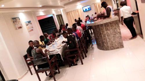 un groupe de personnes assises à table dans un restaurant dans l'établissement Hotel du Golfe de Guinée, à Conakry