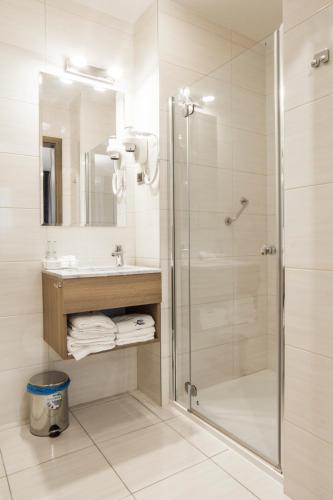 a bathroom with a shower and a sink at Hotel Urbi in Gdańsk