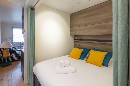 - une chambre avec un lit doté d'oreillers jaunes et bleus dans l'établissement La Cabine by Cocoonr, à Saint-Malo