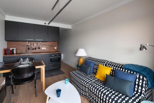 un salon avec un canapé et une cuisine dans l'établissement La Cabine by Cocoonr, à Saint-Malo