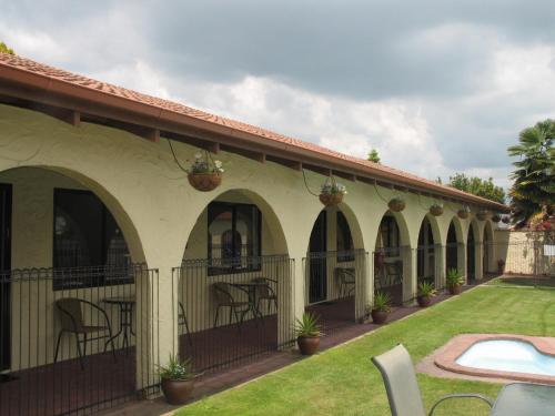 un patio de una casa con sillas y plantas en Captains Quarters Motor Inn, en Cambridge