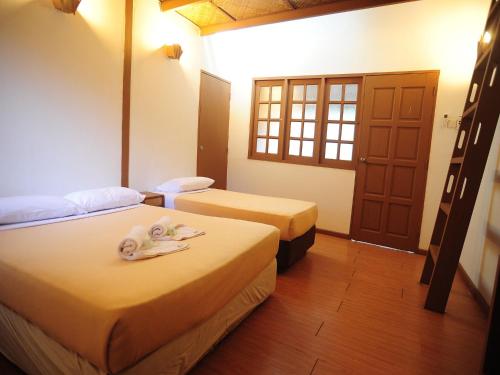 a hotel room with two beds with towels on them at Redang Paradise Resort in Redang Island