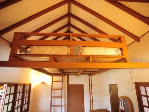 a loft bed in a room with two bunk beds at Redang Paradise Resort in Redang Island