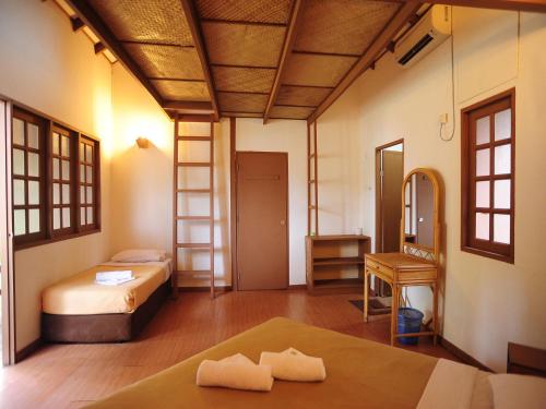 a bedroom with a bed and a mirror in a room at Redang Paradise Resort in Redang Island