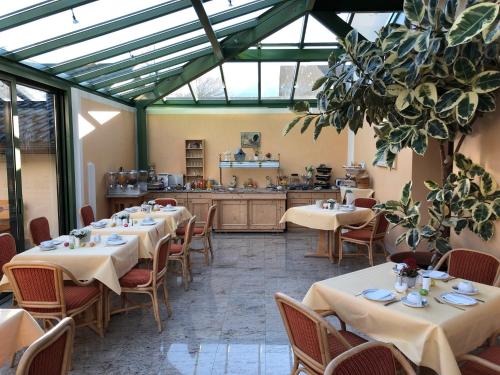 ein Restaurant mit Tischen und Stühlen und eine Küche in der Unterkunft Gästehaus Maria in Garmisch-Partenkirchen