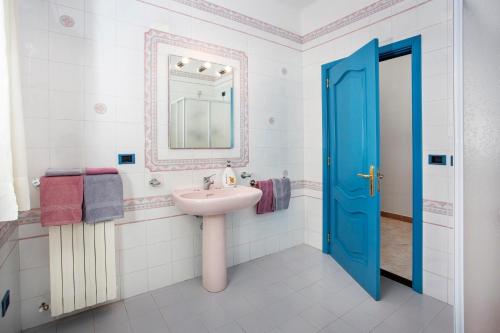 a bathroom with a sink and a blue door at Villa Eva in Crispiano